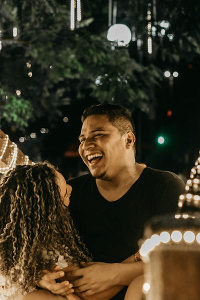Couple qui rit sous des guirlandes